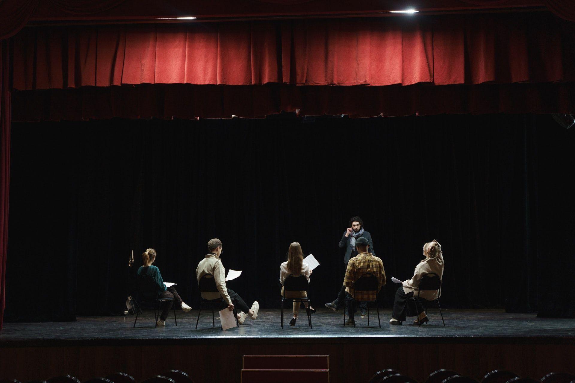 Actors reading a script on a theater stage